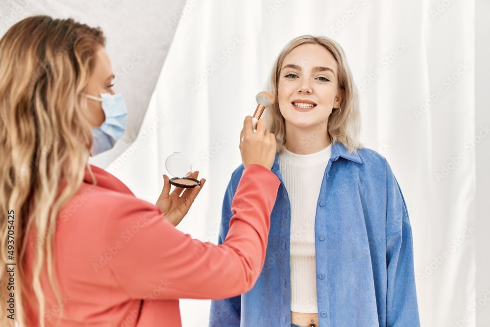 Stylist woman applying make up to beautiful caucasian model at photo shoot backstage, getting ready for professional photoshoot Stylist woman applying make up to beautiful caucasian model at photo shoot backstage, getting ready for professional photoshoot