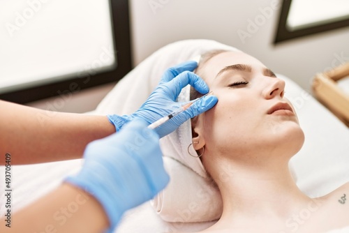 Doctor injecting botox on woman face for anti aging treatment at the clinic.