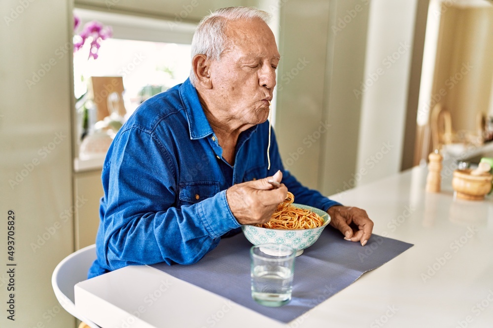 Senior man eating spaghetti at kitchen Senior man eating spaghetti at kitchen