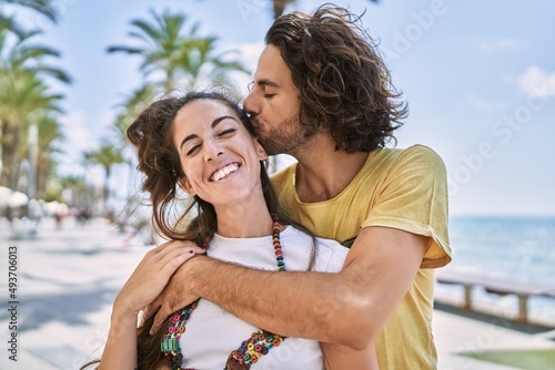 Man and woman couple kissing and hugging each other at seaside