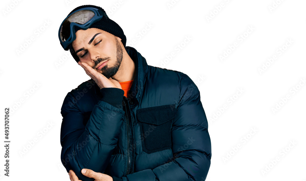 Young hispanic man with beard wearing snow wear and sky glasses thinking looking tired and bored with depression problems with crossed arms.