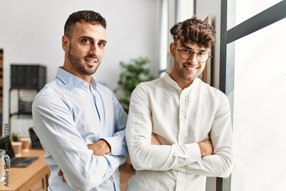 Two hispanic men business workers standing with arms crossed gesture at office Two hispanic men business workers standing with arms crossed gesture at office