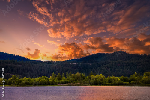 2022-03-19 LAKE COEUR D'ALENE IN IDAHO WITH A TREE LINED SHORE AND BEAUTIFUL SKY AND SUNSET. photo