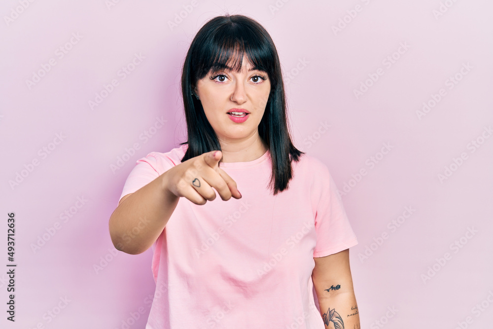 Young hispanic woman wearing casual clothes pointing displeased and frustrated to the camera, angry and furious with you Young hispanic woman wearing casual clothes pointing displeased and frustrated to the camera, angry and furious with you