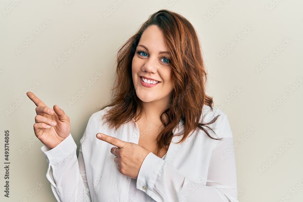 Young caucasian woman wearing casual clothes smiling and looking at the camera pointing with two hands and fingers to the side. Young caucasian woman wearing casual clothes smiling and looking at the camera pointing with two hands and fingers to the side.