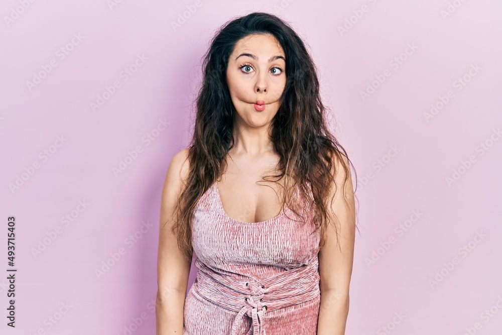 Young hispanic woman wearing casual clothes making fish face with lips, crazy and comical gesture. funny expression. Young hispanic woman wearing casual clothes making fish face with lips, crazy and comical gesture. funny expression.