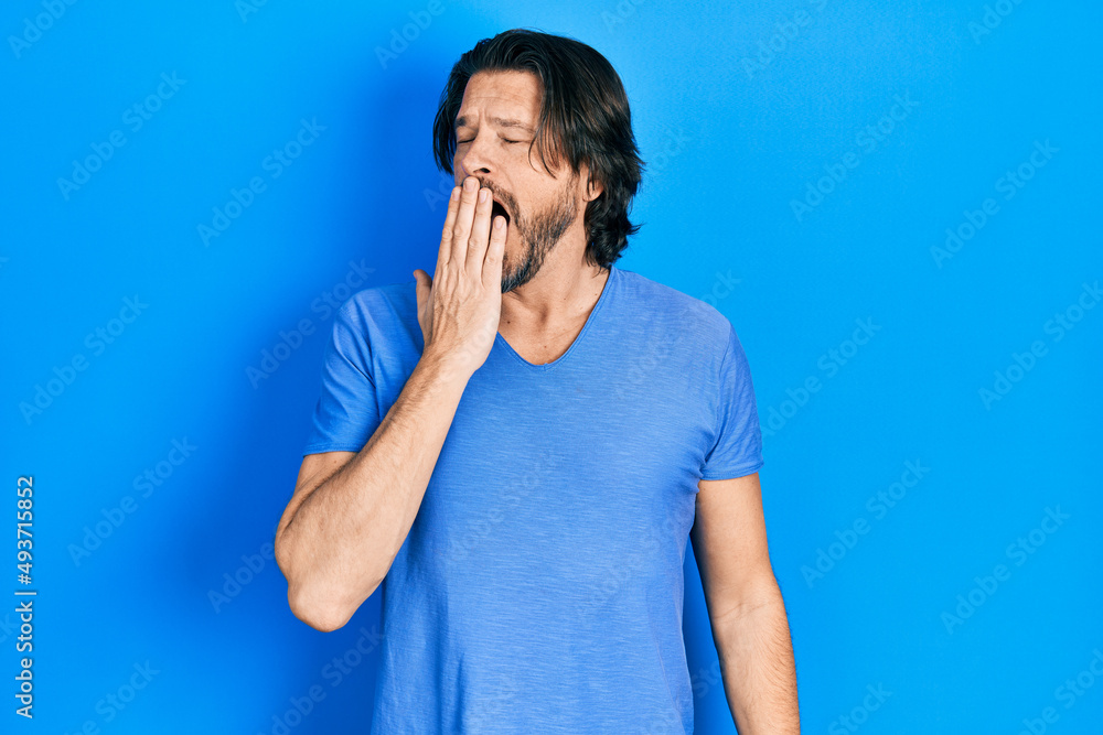 Middle age caucasian man wearing casual clothes bored yawning tired covering mouth with hand. restless and sleepiness. Middle age caucasian man wearing casual clothes bored yawning tired covering mouth with hand. restless and sleepiness.
