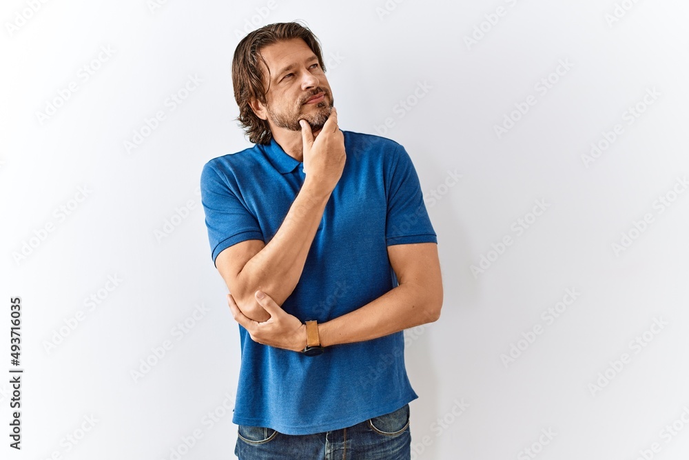 Handsome middle age man standing together over isolated background with hand on chin thinking about question, pensive expression. smiling with thoughtful face. doubt concept. Handsome middle age man standing together over isolated background with hand on chin thinking about question, pensive expression. smiling with thoughtful face. doubt concept.