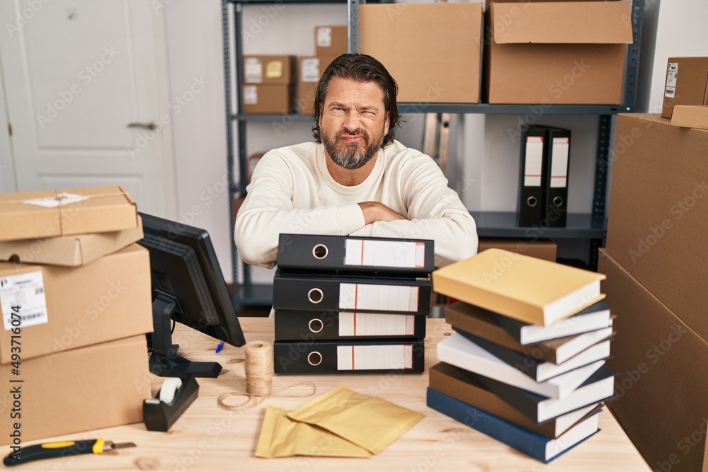 Handsome middle age man working at small business ecommerce skeptic and nervous, frowning upset because of problem. negative person. Handsome middle age man working at small business ecommerce skeptic and nervous, frowning upset because of problem. negative person.