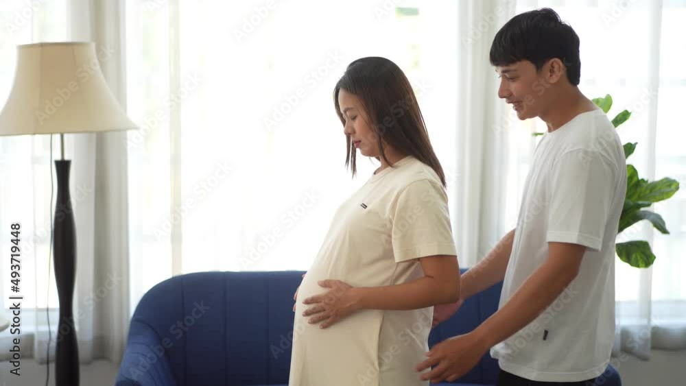 Romantic sweet asian couple husband hugging and smiling beauty asian pregnant wife.Man expecting with woman pregnancy hold to baby in belly at home Romantic sweet asian couple husband hugging and smiling beauty asian pregnant wife.Man expecting with woman pregnancy hold to baby in belly at home