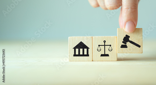 Wooden cube block shape with icon law legal justice. Law business and justice banner. Modern flat cube block design with court, scale and justice symbols on smart grey background and copy space. photo