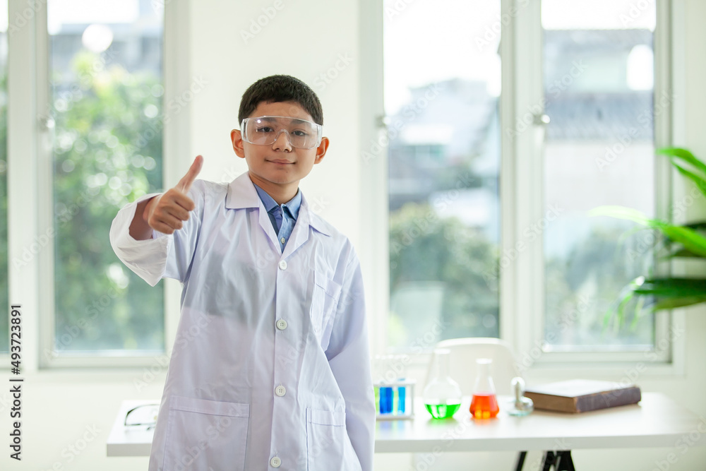 Little boy mixes chemicals in beakers. kids standing with test tube at school laboratory. Little boy mixes chemicals in beakers. kids standing with test tube at school laboratory.
