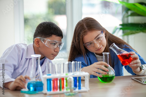Students mixes chemicals in beakers. Chemistry student mixes chemicals in science class