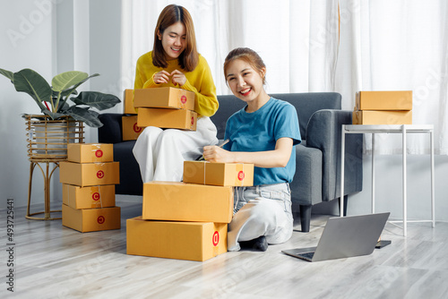 Two Asian Young business woman on sofa at home. startup sme small business entrepreneur SME distribution warehouse with parcel mail box. SME Online marketing and product packaging and delivery service © David
