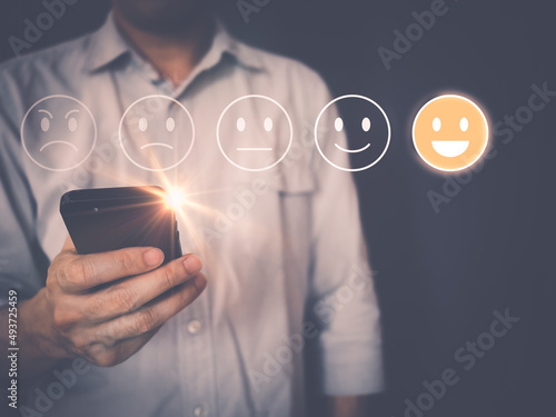 Customer satisfaction survey Concept, man using smartphone choose Satisfaction feedback, rated as excellent, happy smiley face icon