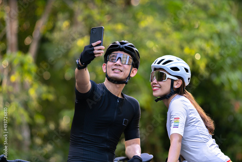 happy couple cycle selfie with smart phone during ride on rode in countryside for health life style