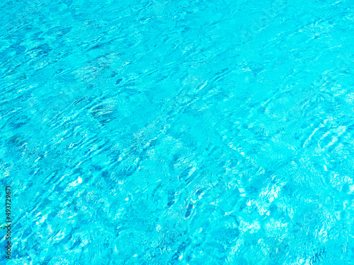 Clean and clear blue water surface movement on the swimming pool background. Empty blank space for summer background, vacation time, holiday concept.