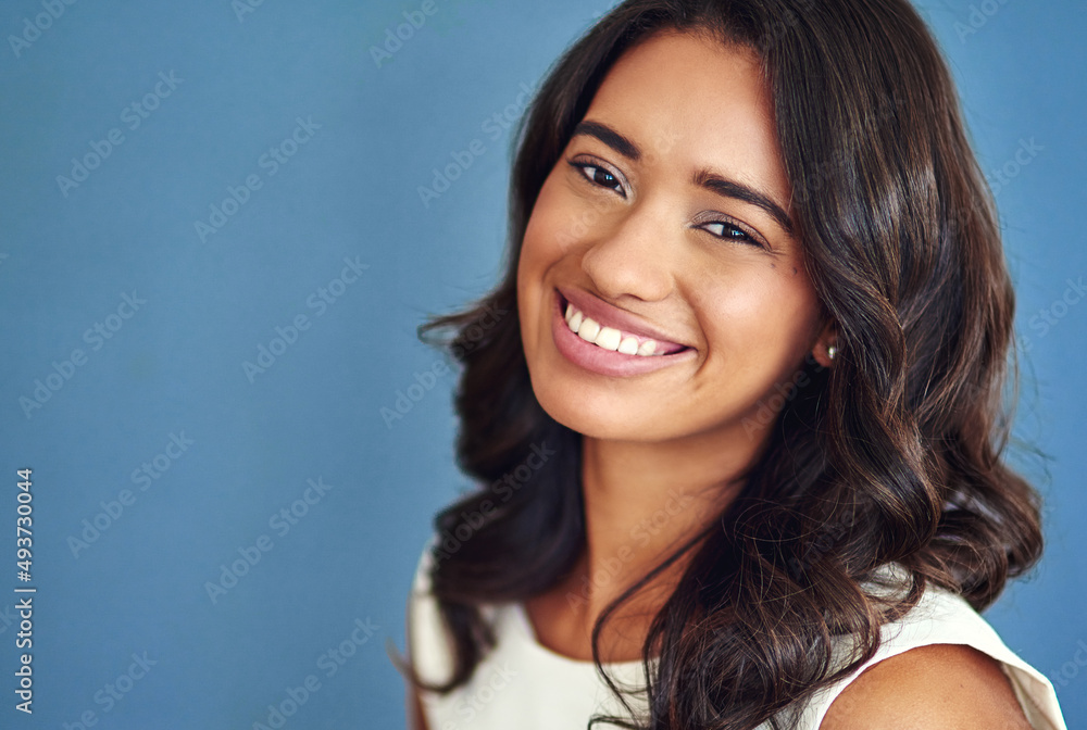 Its all about confidence. Studio portrait of a confident young woman posing against a blue background. Its all about confidence. Studio portrait of a confident young woman posing against a blue background.