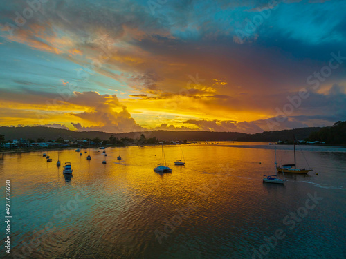 Aerial sunrise waterscape with boats, colour and clouds © Merrillie