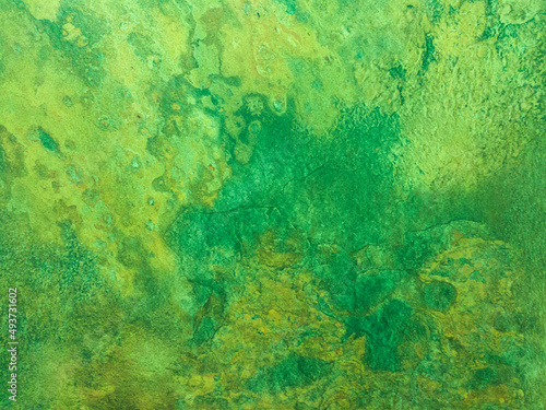 A rusty green metal wall with spots and scuffs. Vintage background with texture. Rough surface. 