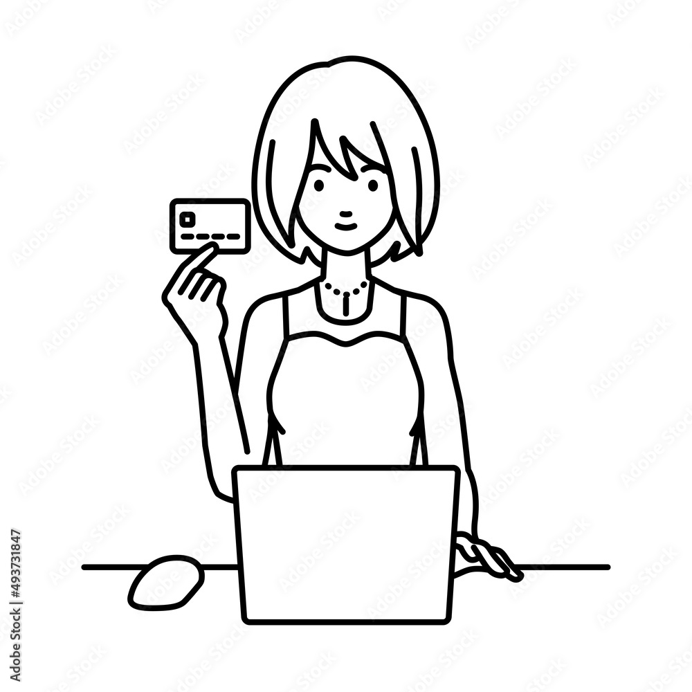 デスクで座ってPCを使いながらクレジットカードを手に持っているドレスの女性