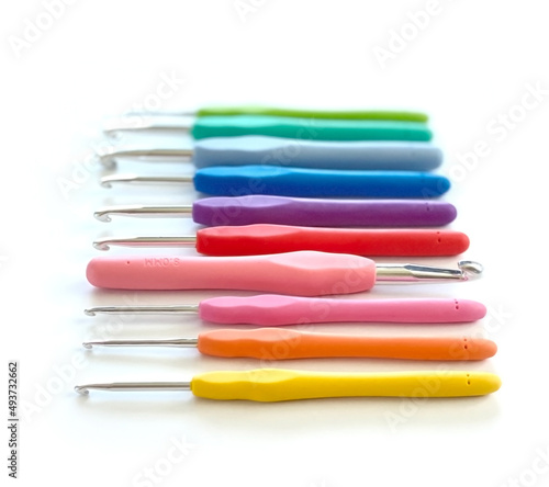 Colorful crochet hooks in different sizes for knitting isolated on white background in soft focus