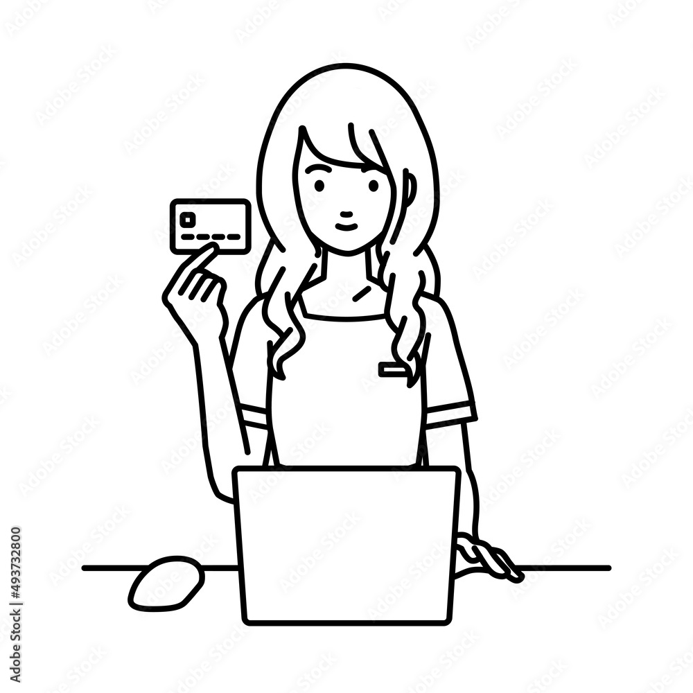 デスクで座ってPCを使いながらクレジットカードを手に持っているエステ店員・受付の女性
