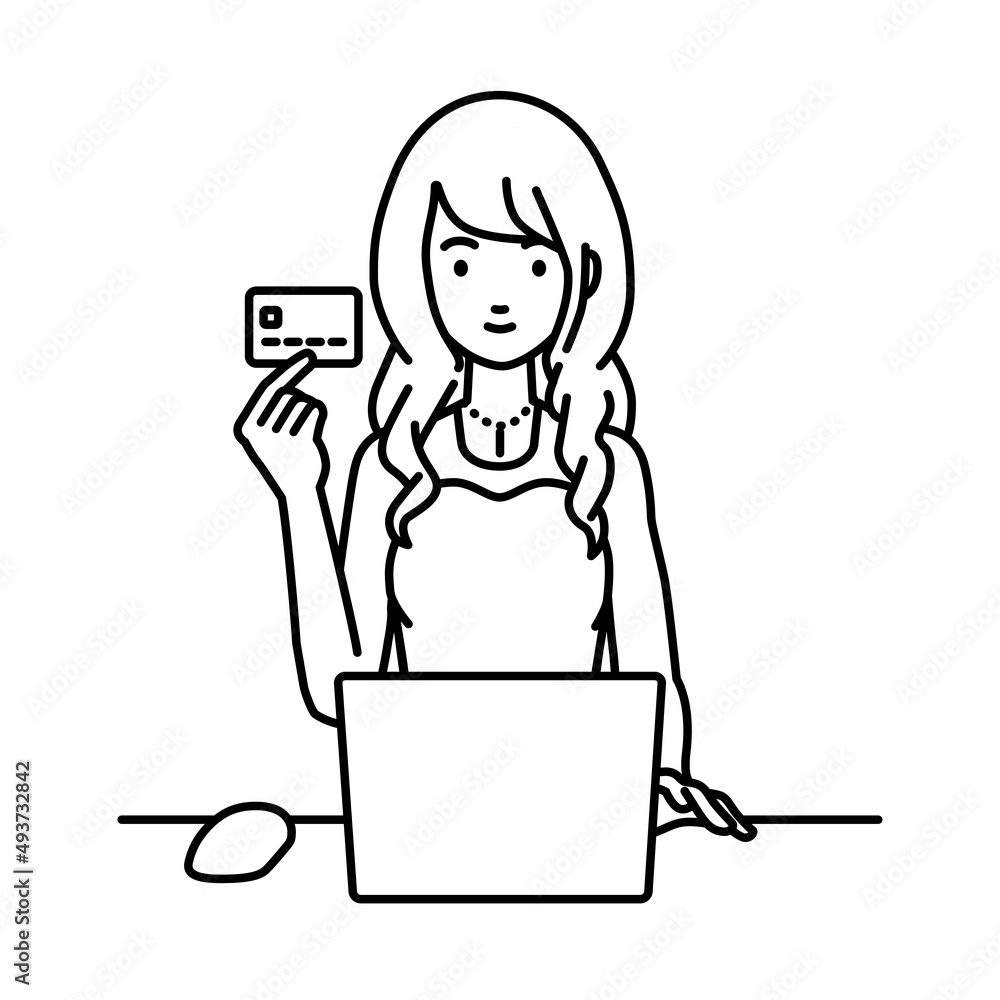デスクで座ってPCを使いながらクレジットカードを手に持っているドレスの女性