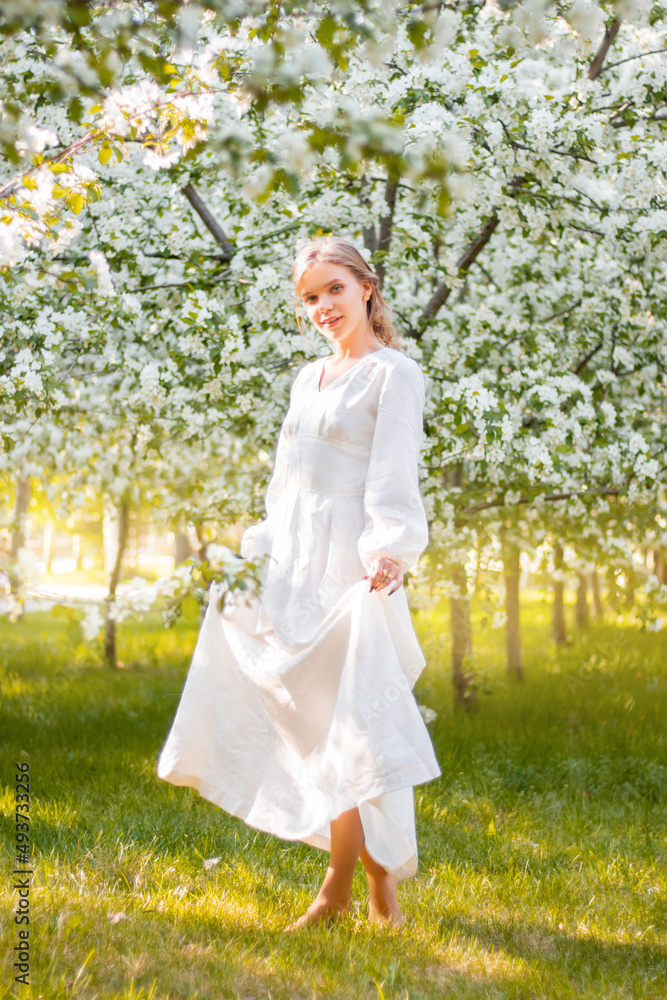 Young woman in a white dress against the backdrop of blooming apple trees. The girl poses against the background of flowers in the spring park.
Young woman in a white dress against the backdrop of blooming apple trees. The girl poses against the background of flowers in the spring park.