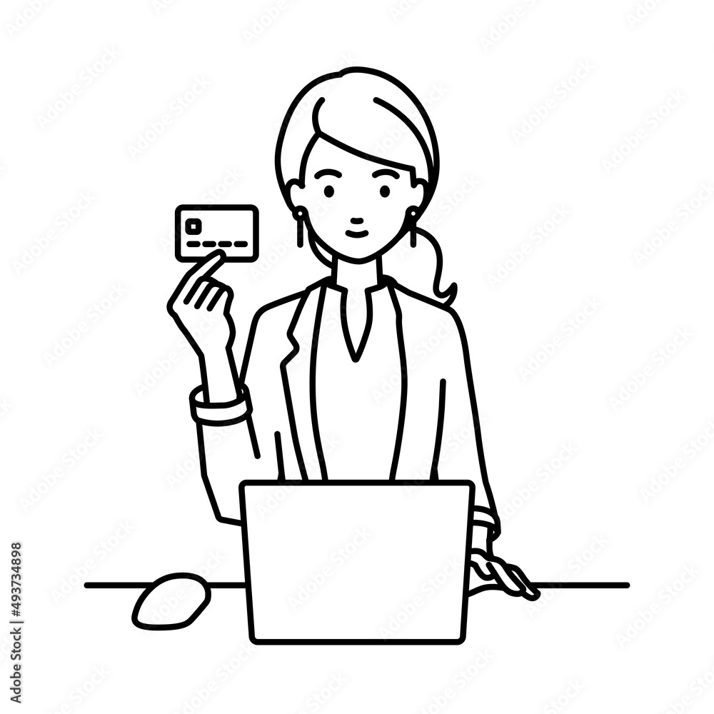 デスクで座ってPCを使いながらクレジットカードを手に持っているジャケットの女性