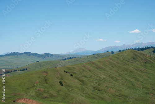 Beautiful green mountains with blue sky background. Santash mountain pass in Kyrgyzstan.