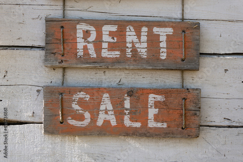 Inscription of the words rent and sale on wooden red boards