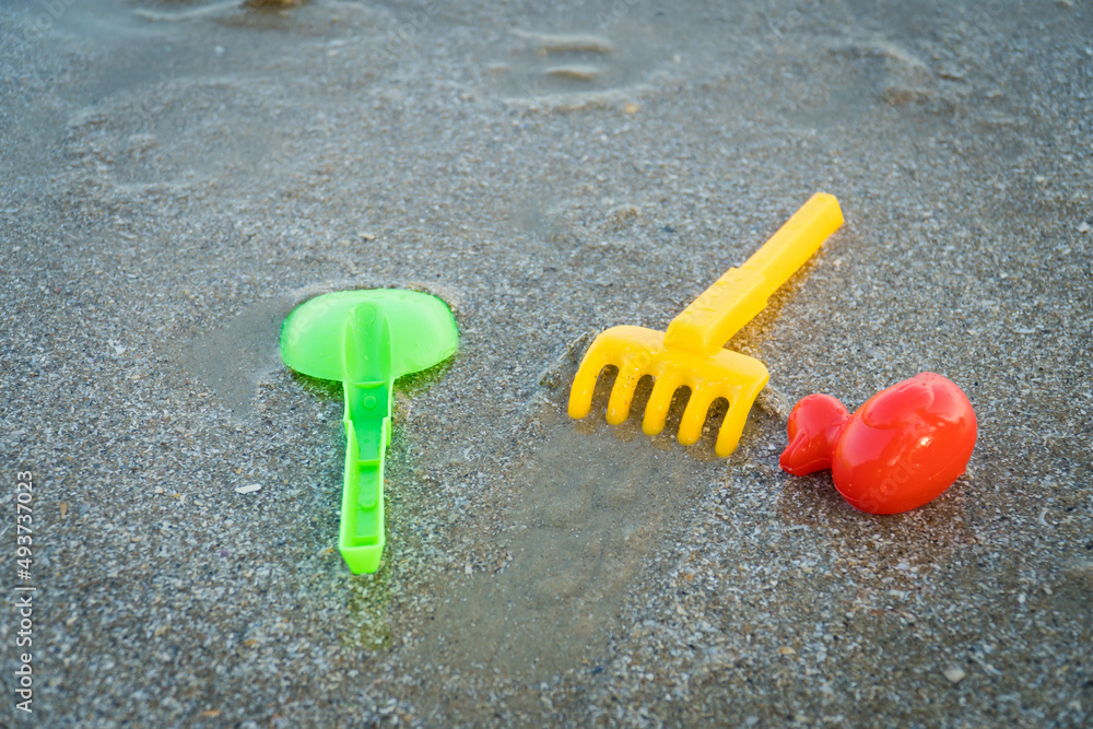 Children's beach toys. plastic children toys on the sand beach. copy space for text. Children's beach toys. plastic children toys on the sand beach. copy space for text.