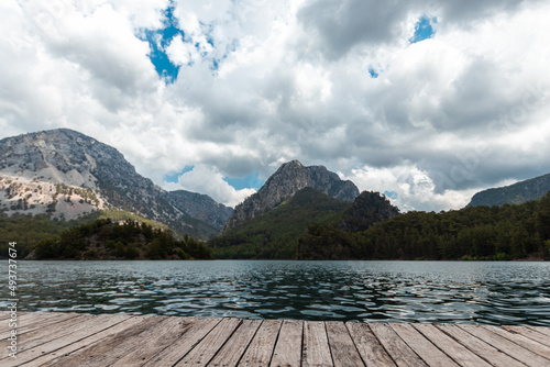Boards background with landscape of mountains and lake for your decoration. Beautiful nature, white clouds, template table. © Aliaksandr Marko