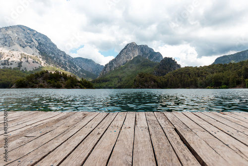 Boards background with landscape of mountains and lake for your decoration. Beautiful nature  white clouds  template table.