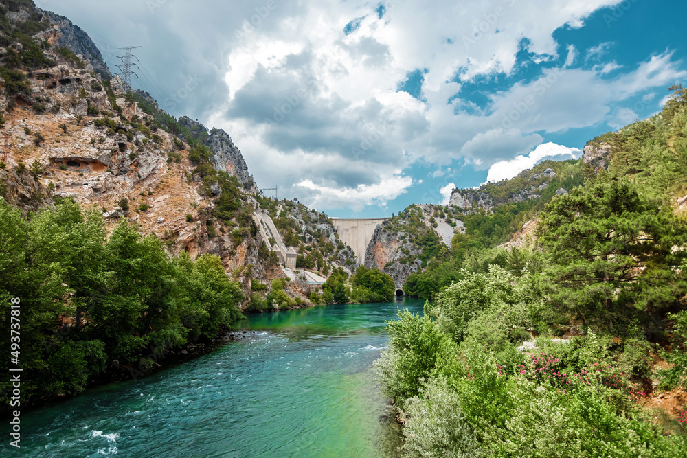Concrete Dam among the rocks. Reservoir, hydroelectric power plant, clean electricity.