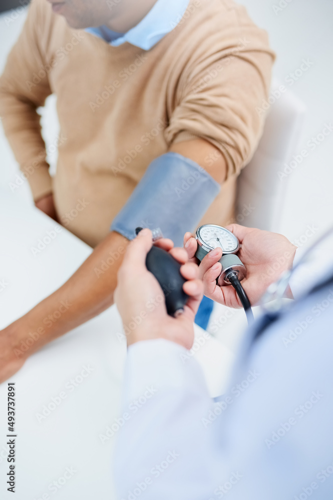 Checking his blood pressure. High angle shot of a male doctor taking a patients blood pressure. Checking his blood pressure. High angle shot of a male doctor taking a patients blood pressure.