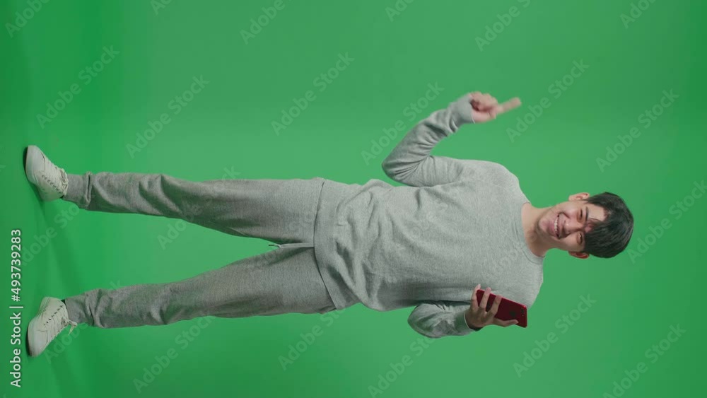 Full Body Of Asian Man Flipping Through The Mobile Phone With A Smile Pointing To The Side While Standing In The Green Screen
Full Body Of Asian Man Flipping Through The Mobile Phone With A Smile Pointing To The Side While Standing In The Green Screen