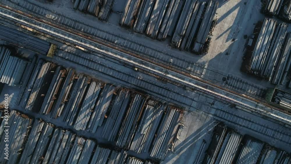 Top down aerial view of Round metal pipes in Metal warehouse. Industrial outdoors storage site with railways.
Top down aerial view of Round metal pipes in Metal warehouse. Industrial outdoors storage site with railways.