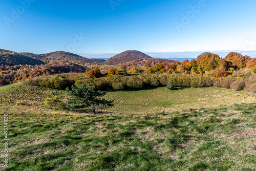 Cratère du volcan du puy des Goules avec en arrière plan plusieurs volcans de la chaine des puys dans le parc naturel d'Auvergne par une belle journée d'automne