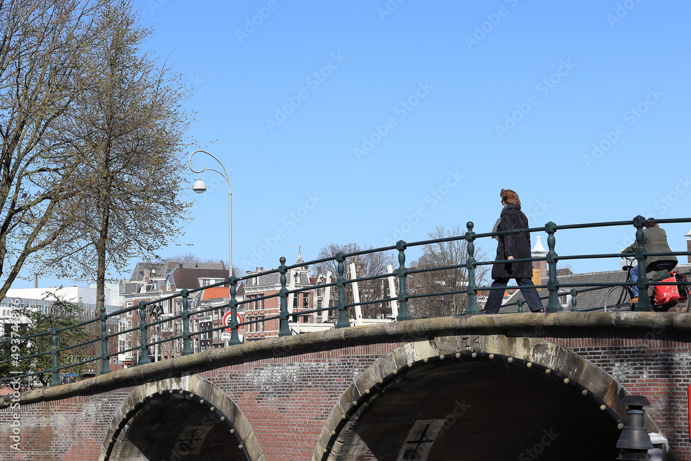 Amsterdam Herengracht Canal Stone Bridge Close Up with Walking Woman, Netherlands