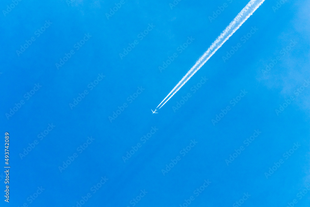 An air plane fly over the clear blue sky with contrail behind. An air plane fly over the clear blue sky with contrail behind.