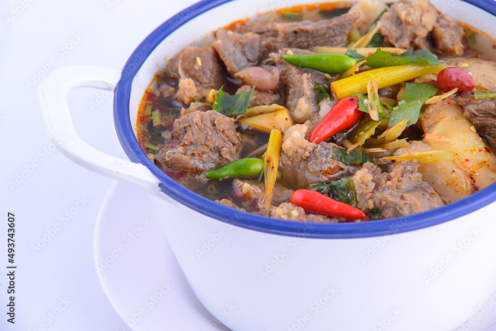 Thai favorite food. Spicy chicken soup (Tom Yum Gai Baan) in the white bowl. Thai favorite food. Spicy chicken soup (Tom Yum Gai Baan) in the white bowl.