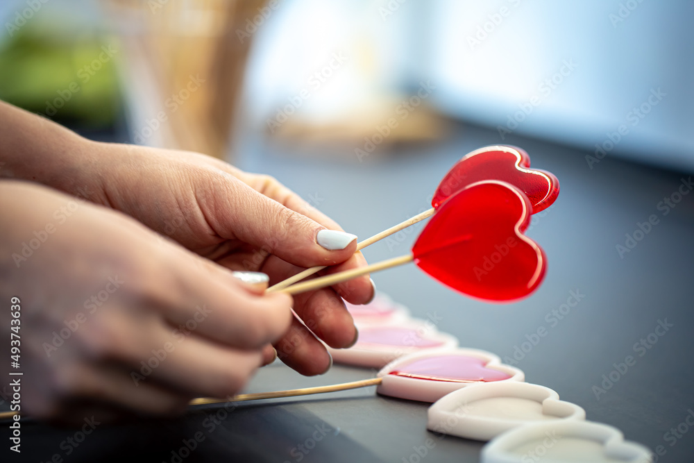 Close-up, the process of making heart-shaped lollipops. Close-up, the process of making heart-shaped lollipops.