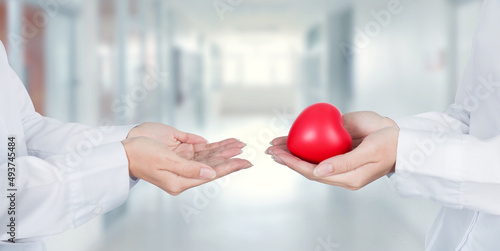 Doctor hands holding a red heart to each other at hospital office and good relationships with heart./Medical health care service concept.