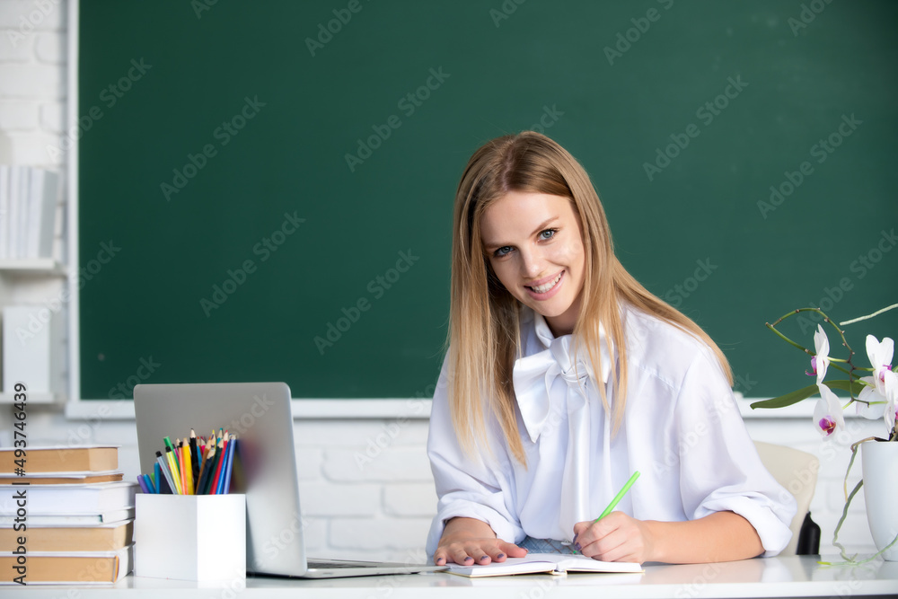Female student writing on notebook on lesson lecture in classroom at high school or college. Female student writing on notebook on lesson lecture in classroom at high school or college.
