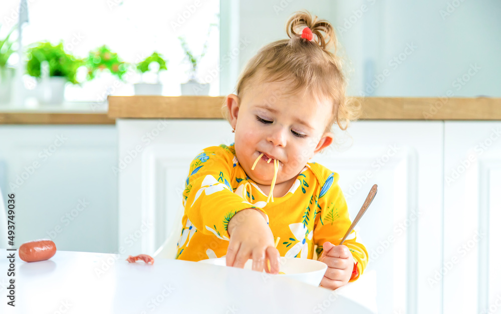 children in the kitchen at the table turning pasta.