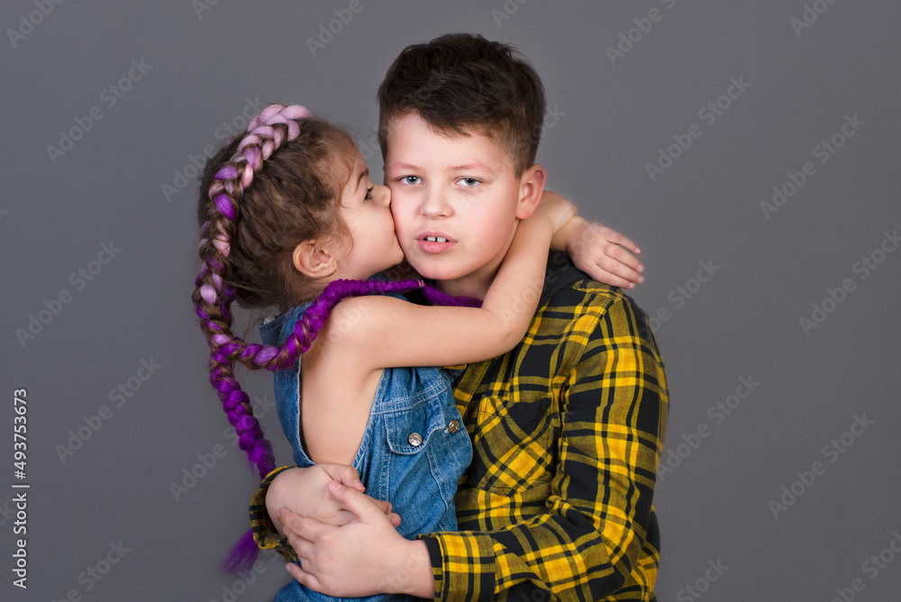 Brother and sister hug. Children on a gray background Brother and sister hug. Children on a gray background
