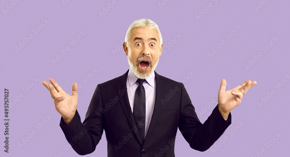 Wow it's amazing. Studio shot of senior businessman surprised by something extraordinary. White haired mature man in suit and necktie opens mouth and looks at camera with funny shocked face expression Wow it's amazing. Studio shot of senior businessman surprised by something extraordinary. White haired mature man in suit and necktie opens mouth and looks at camera with funny shocked face expression
