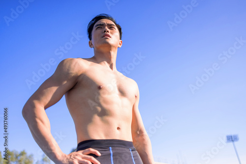 Handsome Asian Sportsman With Strong Muscular Body standing on the stadium